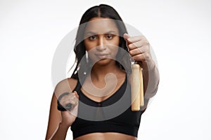 Lets jump a little. Studio portrait of a sporty young woman posing with a skipping rope around her neck against a white