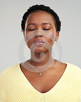 Lets just be who we really are. Closeup shot of a beautiful young woman standing against a grey background.