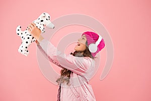 Lets play together. pink is her favorite color. small kid listen music headphones. child long curly hair. cosy winter