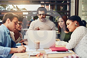 Lets see what we can do to improve the company. Cropped shot of designers having a meeting at a coffee shop.