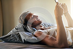 Lets see what everyone is up to this weekend...a young man texting on his cellphone while lying in bed.