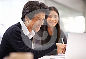 Lets see what we have here. An Asian businessman and woman having a discussion in the office.