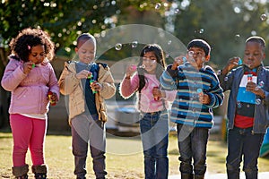 Lets see who can blow the biggest bubble. Cropped shot of a group of little children blowing bubbles together outside.