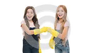 Lets start cleaning. Kids cleaning together. Girls with yellow rubber protective gloves ready for cleaning. Household