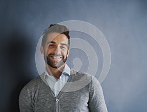 Lets talk business. Portrait of a handsome young businessman posing against a dark background.