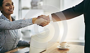 Lets talk business. two businesspeople shaking hands in an office.