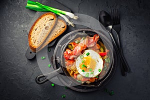 Letscho - tasty Hungarian vegetable stew with peppers, tomatoes and onions, served with bacon and fried egg