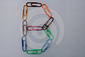 Letter B made with colorful paper clips on white background