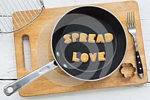 Letter biscuits word SPREAD LOVE and cooking equipments.