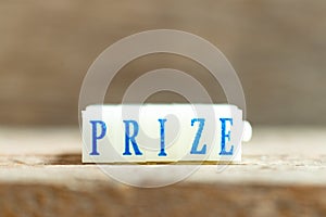 Letter block with blue word prize on wood background