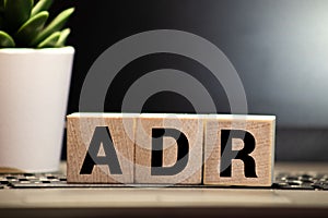 Letter block in word ADR Abbreviation of adverse drug reaction on wood background