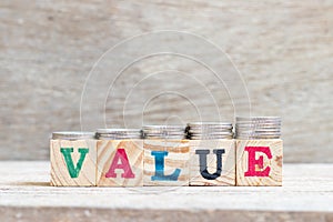 Letter block in word on wood background with coin stack in up trend Concept for profit, sale, value is growing or business