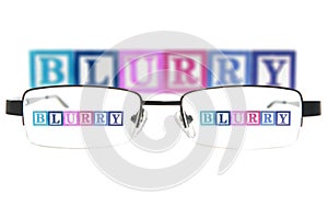 Letter blocks spelling blurry through a pair of glasses photo