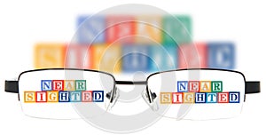 Letter blocks spelling near sighted with a pair of glasses. photo