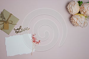 Letter concept with paper, envelop and roses on a pink background.