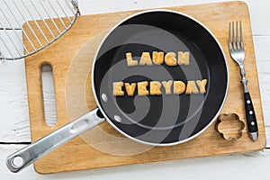 Letter cookies word LAUGH EVERYDAY and kitchen utensils