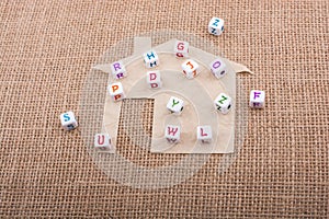 Letter cubes on house cut out of paper