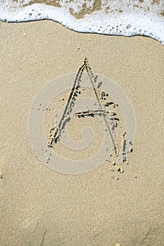 Letter drawn on the sand beach