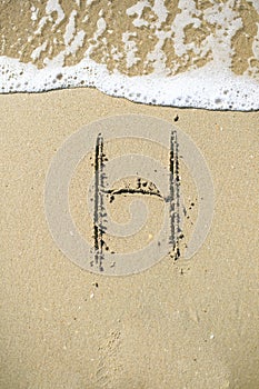 Letter drawn on the sand beach