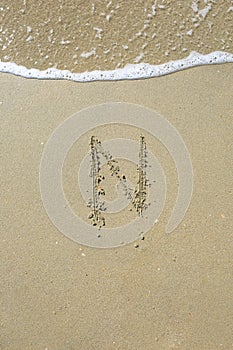 Letter drawn on the sand beach
