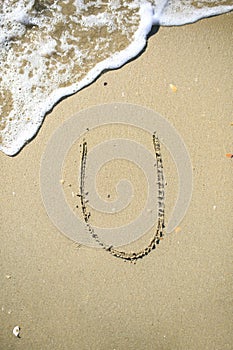 Letter drawn on the sand beach