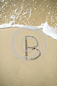 Letter drawn on the sand beach