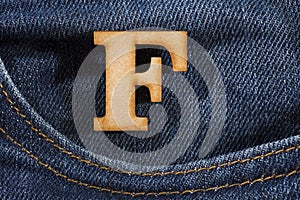 Letter F of the alphabet - blue jeans texture background. Top view