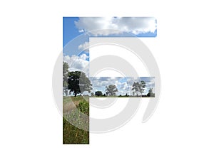 Letter F of the alphabet made with landscape with cloud, blue sky, trees, sun, grass and moorland photo