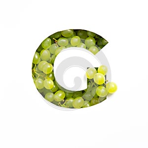 Letter G of English alphabet of fresh grape and cut paper isolated on white. Typeface made of green berries
