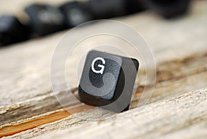 letter g keyboard buttons on old wood background