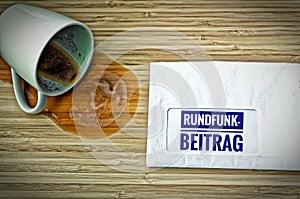 Letter with in german Rundfunkbeitrag in english Radio Post and a dumped coffee cup from fright