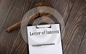 LETTER OF INTENTS text on the paper with gavel on wooden background