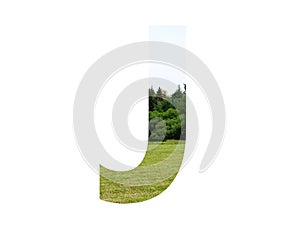 Letter J of the alphabet made with landscape with grass, forest and a blue sky