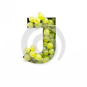 Letter J of English alphabet of green grape and cut paper isolated on white. Typeface of fresh berries