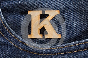 Letter K of the alphabet - blue jeans texture background. Top view