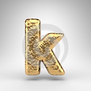 Letter K lowercase on white background. Hammered brass 3D letter with shiny metallic texture