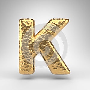 Letter K uppercase on white background. Hammered brass 3D letter with shiny metallic texture
