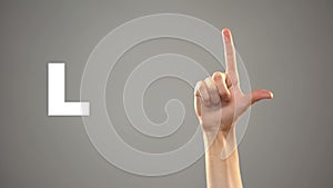 Letter L in sign language, hand on background, communication for deaf, lesson photo