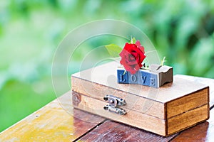 Letter love and red rose on a wood box