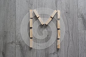 letter M natural wooden blocks on floor alphabet lettering