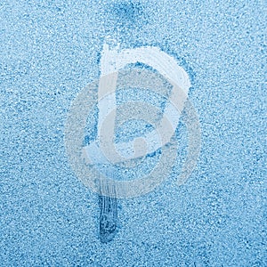 The letter P written on glass with frost in the frost in winter, close up