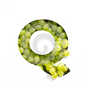 Letter Q of English alphabet of fresh grape and cut paper isolated on white. Typeface of green berries