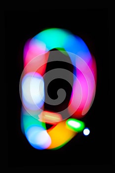 Letter Q. Glowing letters on dark background. Abstract light painting at night. Creative artistic colorful bokeh. New Year.