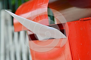 Letter in red mail box on home fence