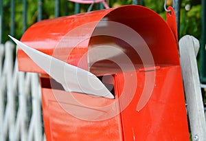 Letter in red post box on home fence