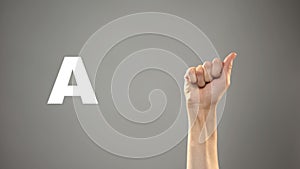 Letter A in sign language, hand on background, communication for deaf, lesson photo