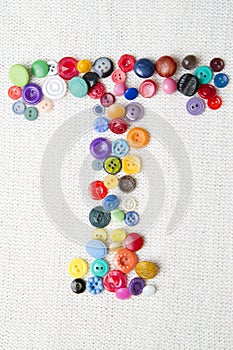 Letter T of the alphabet of buttons of various shapes and colors