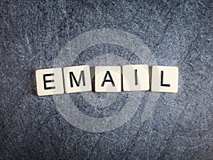 Letter tiles on black slate background spelling Email