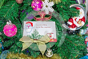 A letter to Santa Claus at the North Pole in Lapland lies with toys and ornaments and on the Christmas tree.