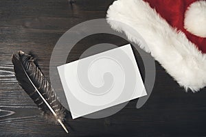 Letter to Santa on a wooden background. Blank sheet, pen and hat . Christmas and New Year concept